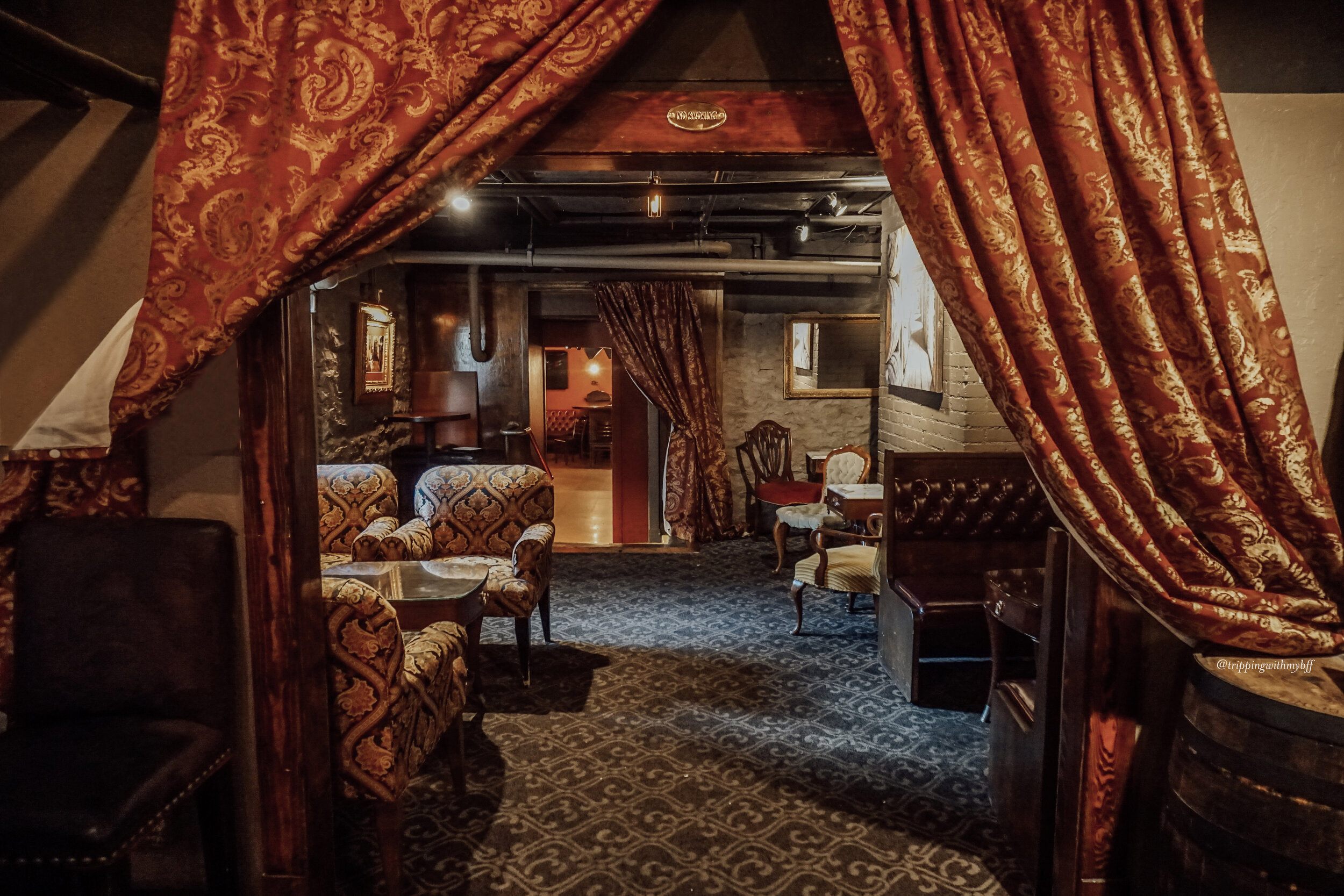 a room with a red curtain and chairs