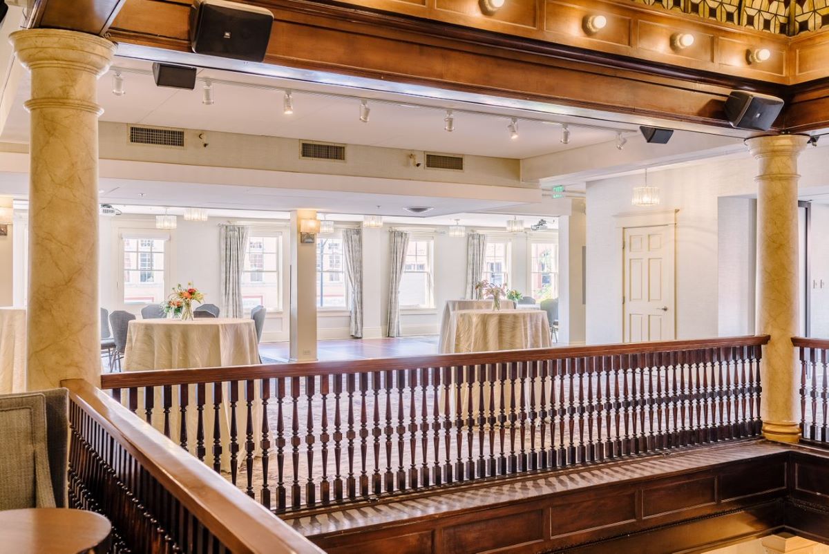a room with a wood railing and tables