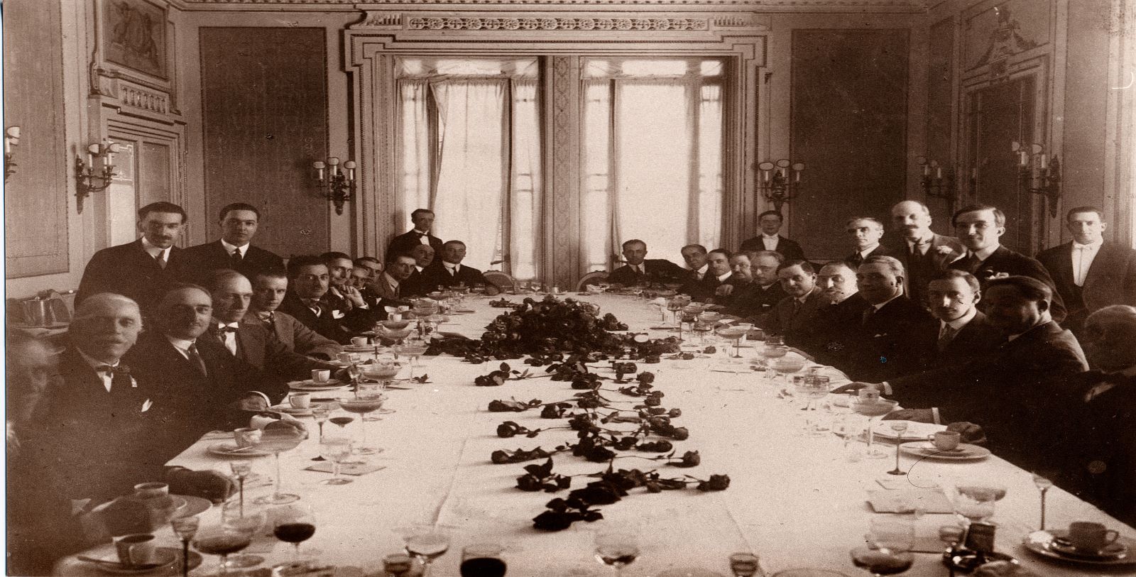 a group of men sitting at a long table