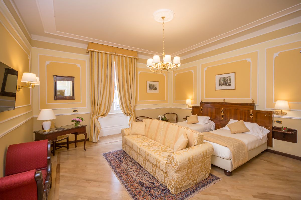 a room with two beds and a chandelier