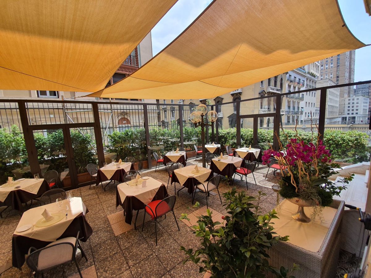a patio with tables and chairs and plants