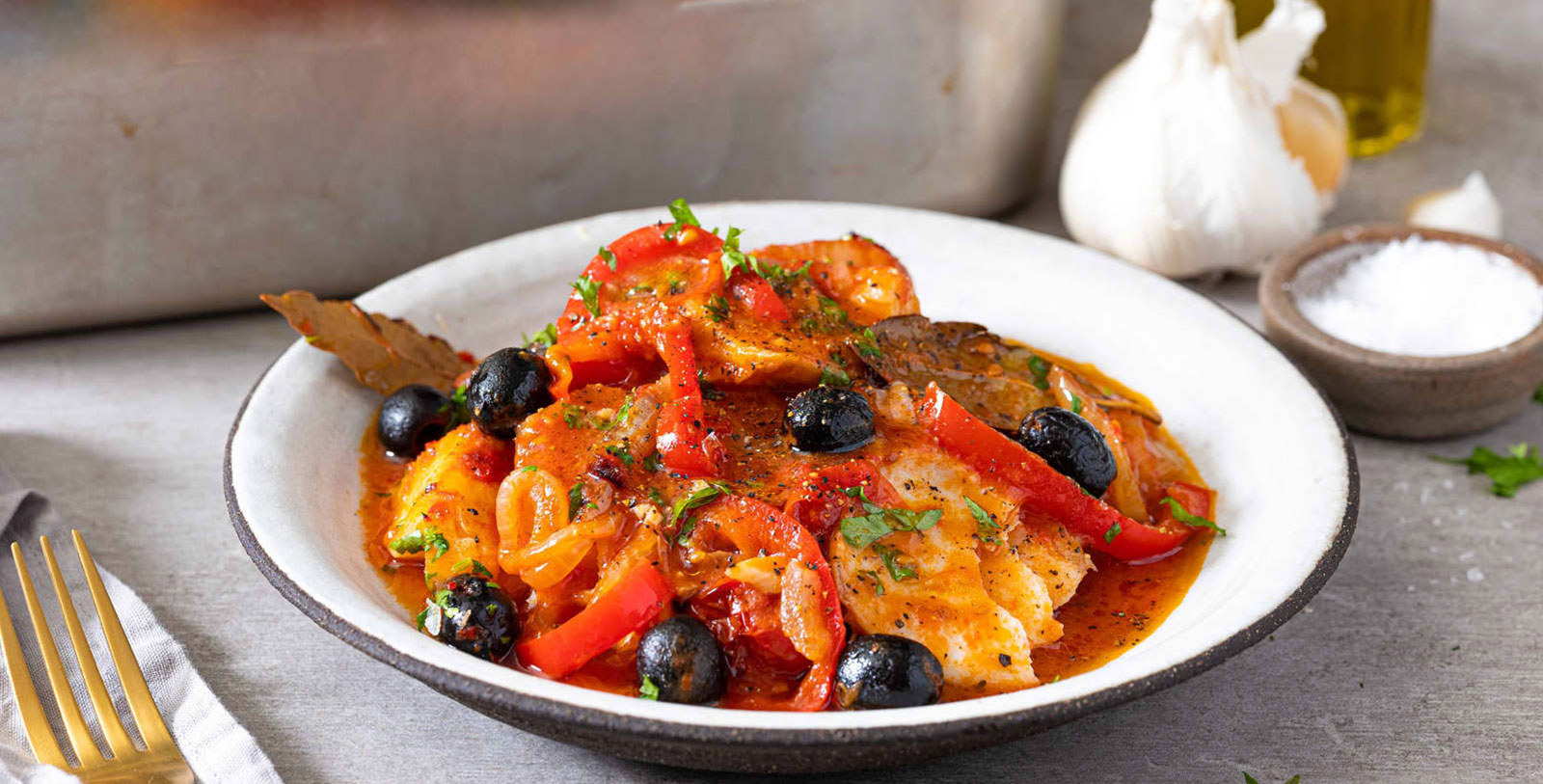 a bowl of food with olives and meat