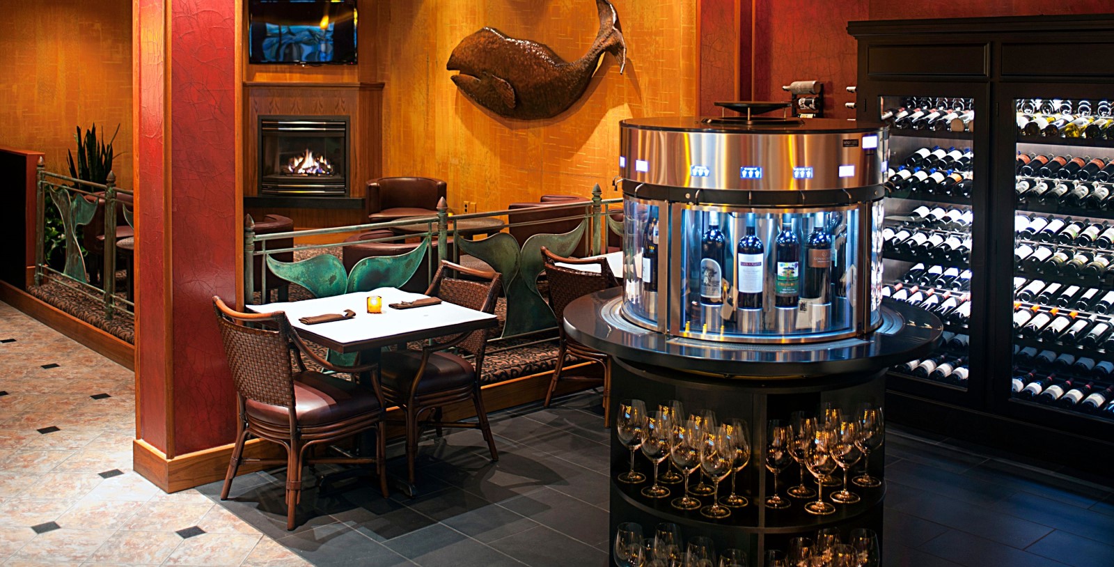 a room with a table and chairs and a table with wine bottles