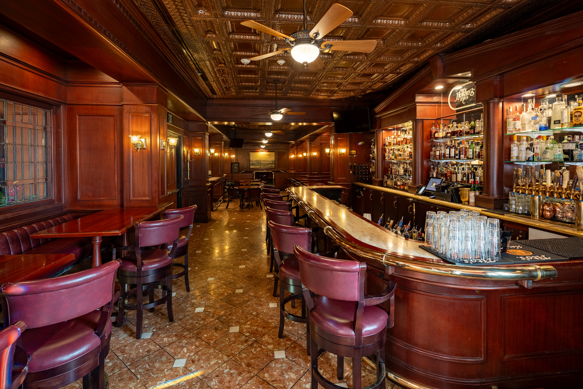 a bar with chairs and a ceiling fan