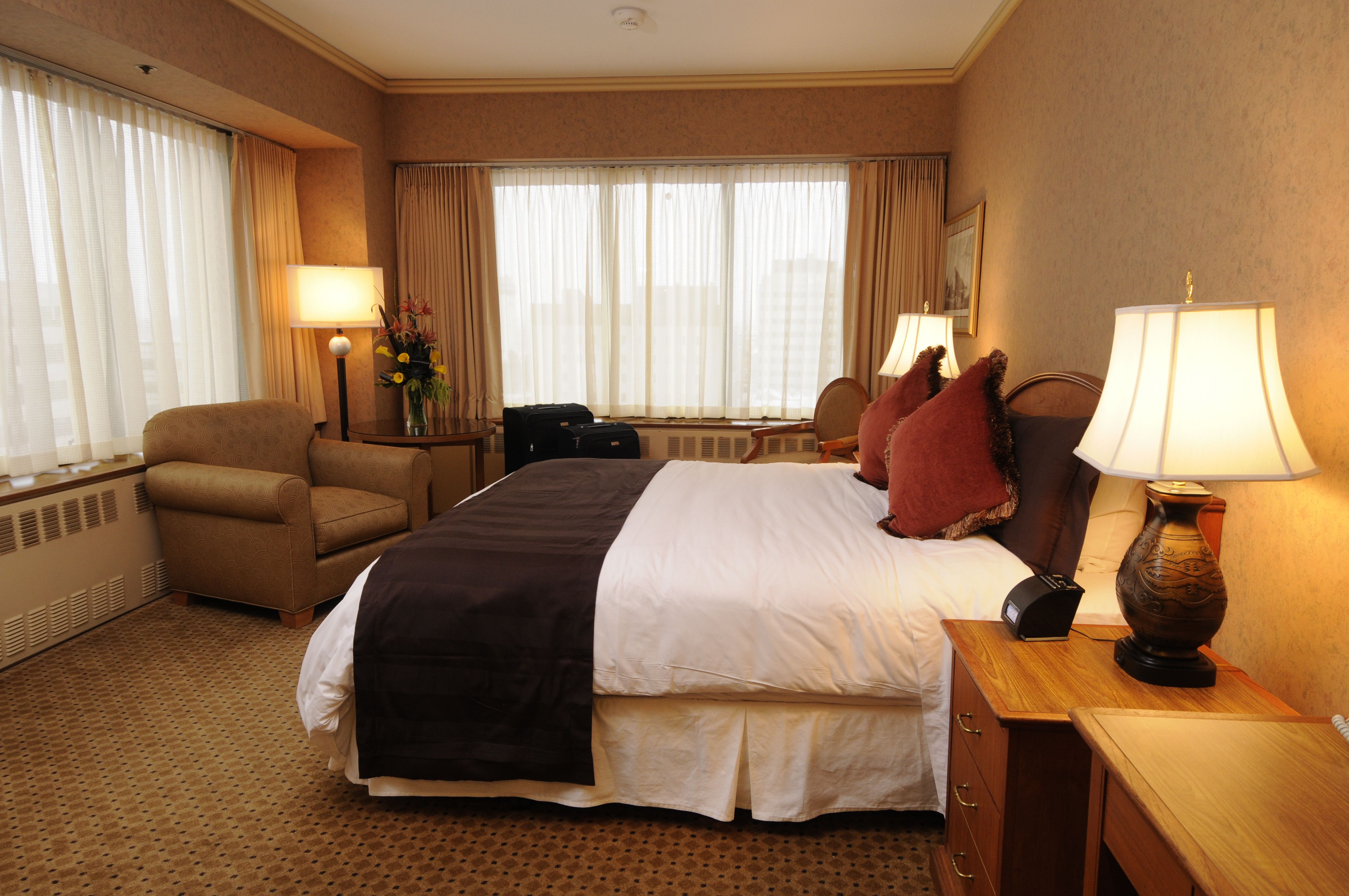 a bedroom with a bed and chairs