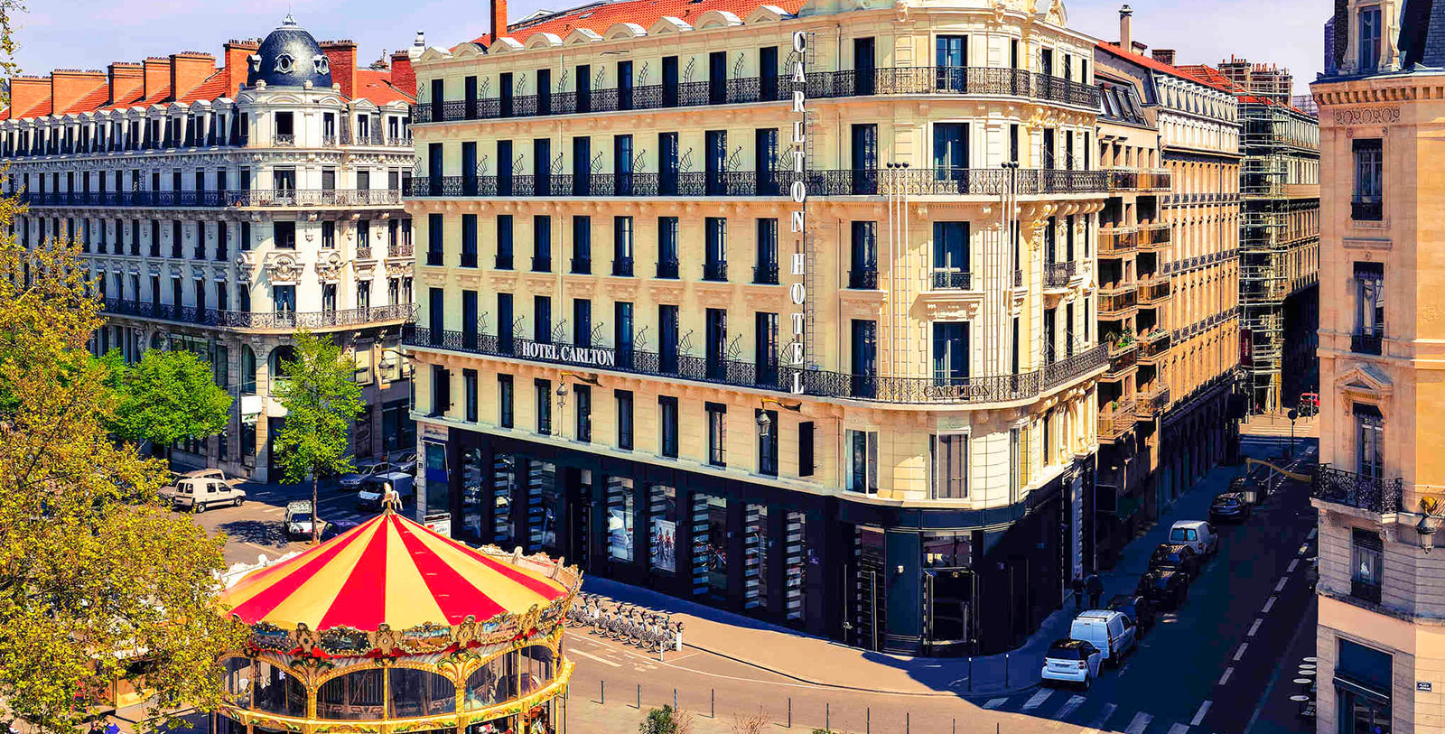 a building with a carousel and cars in the background