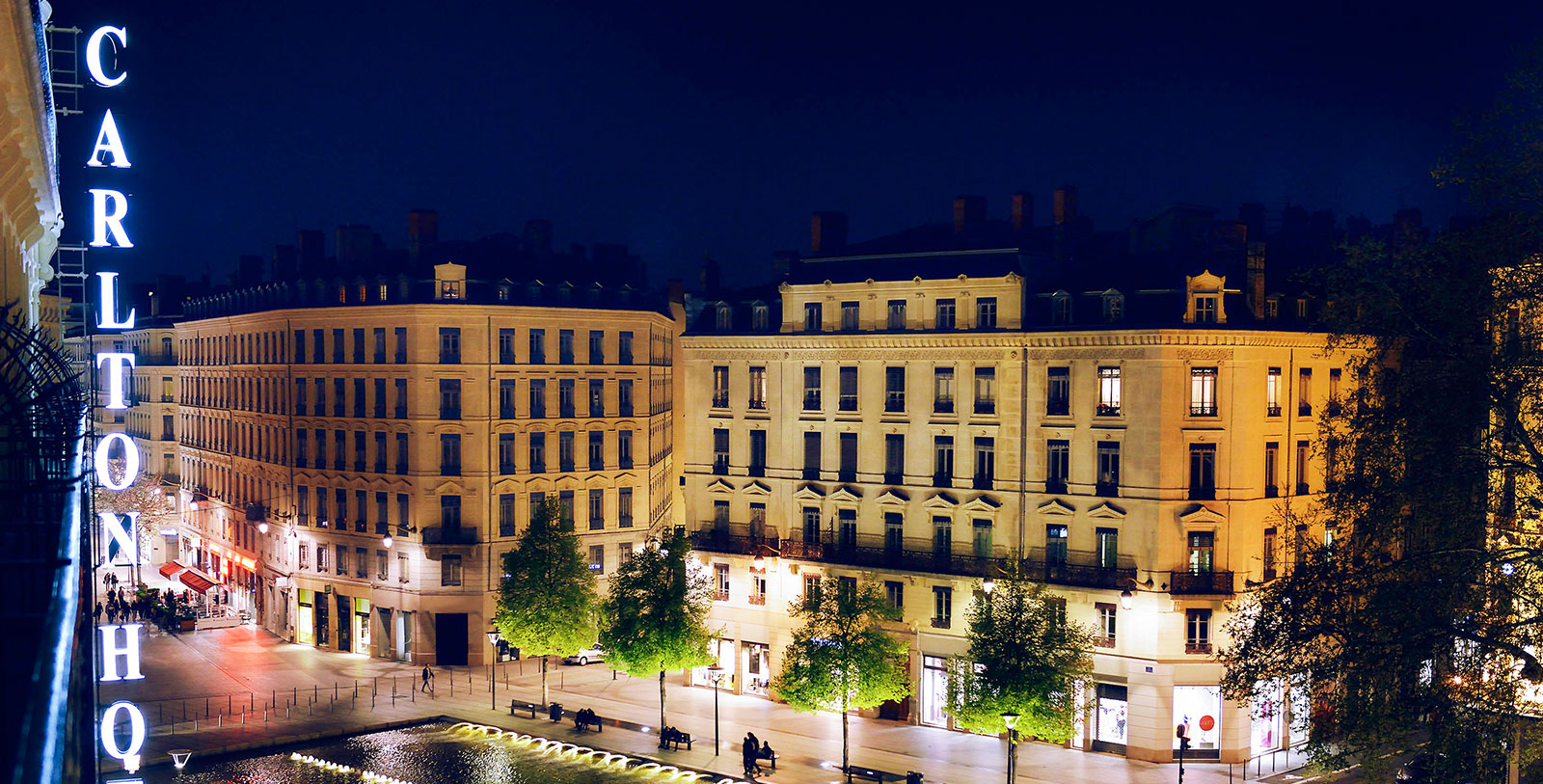a building with trees and lights at night