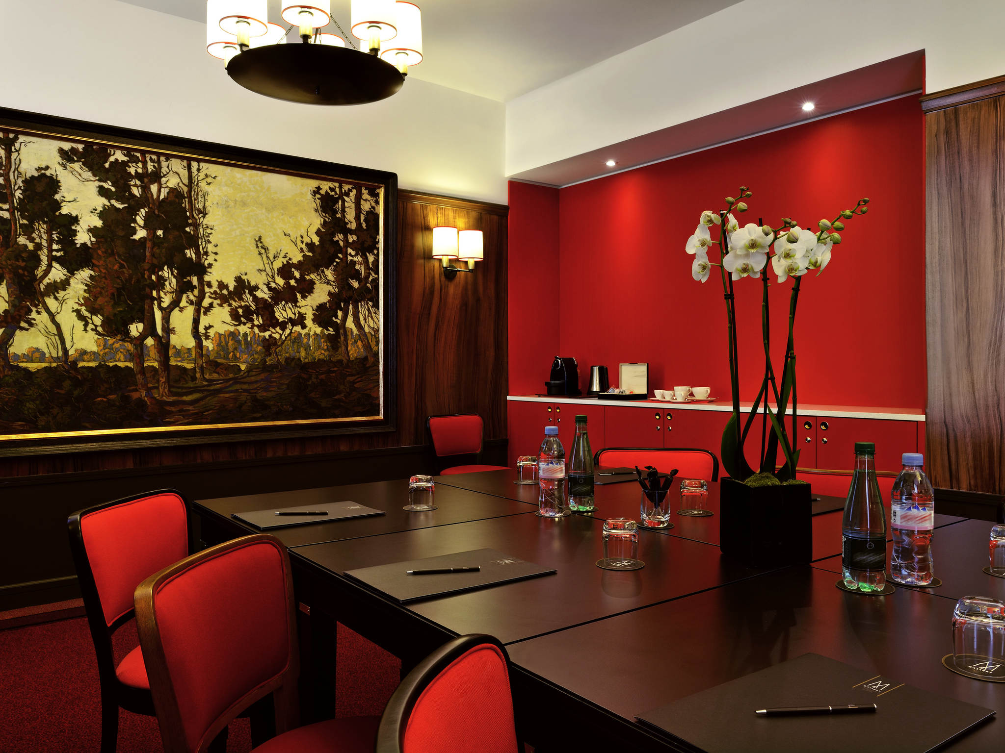 a room with red chairs and a table with red chairs