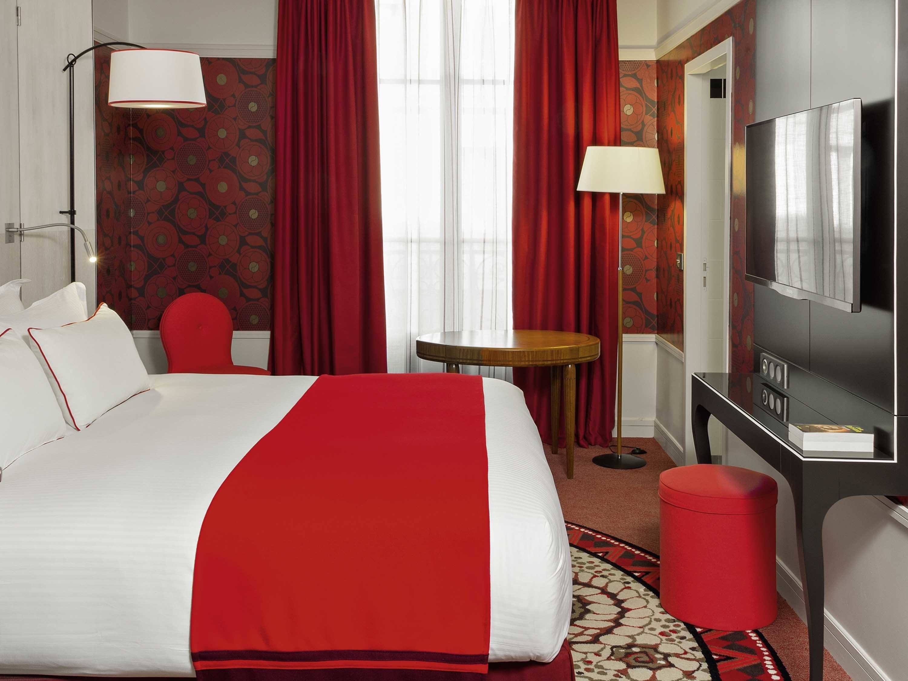 a room with red curtains and a bed