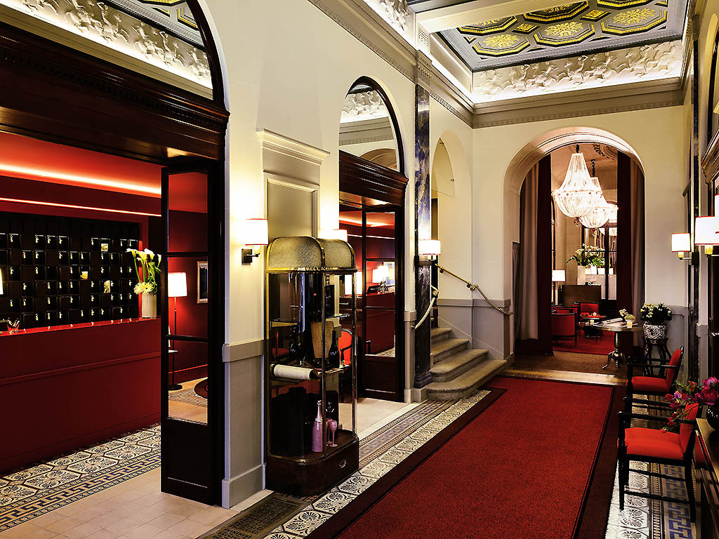 a hallway with red carpet and stairs