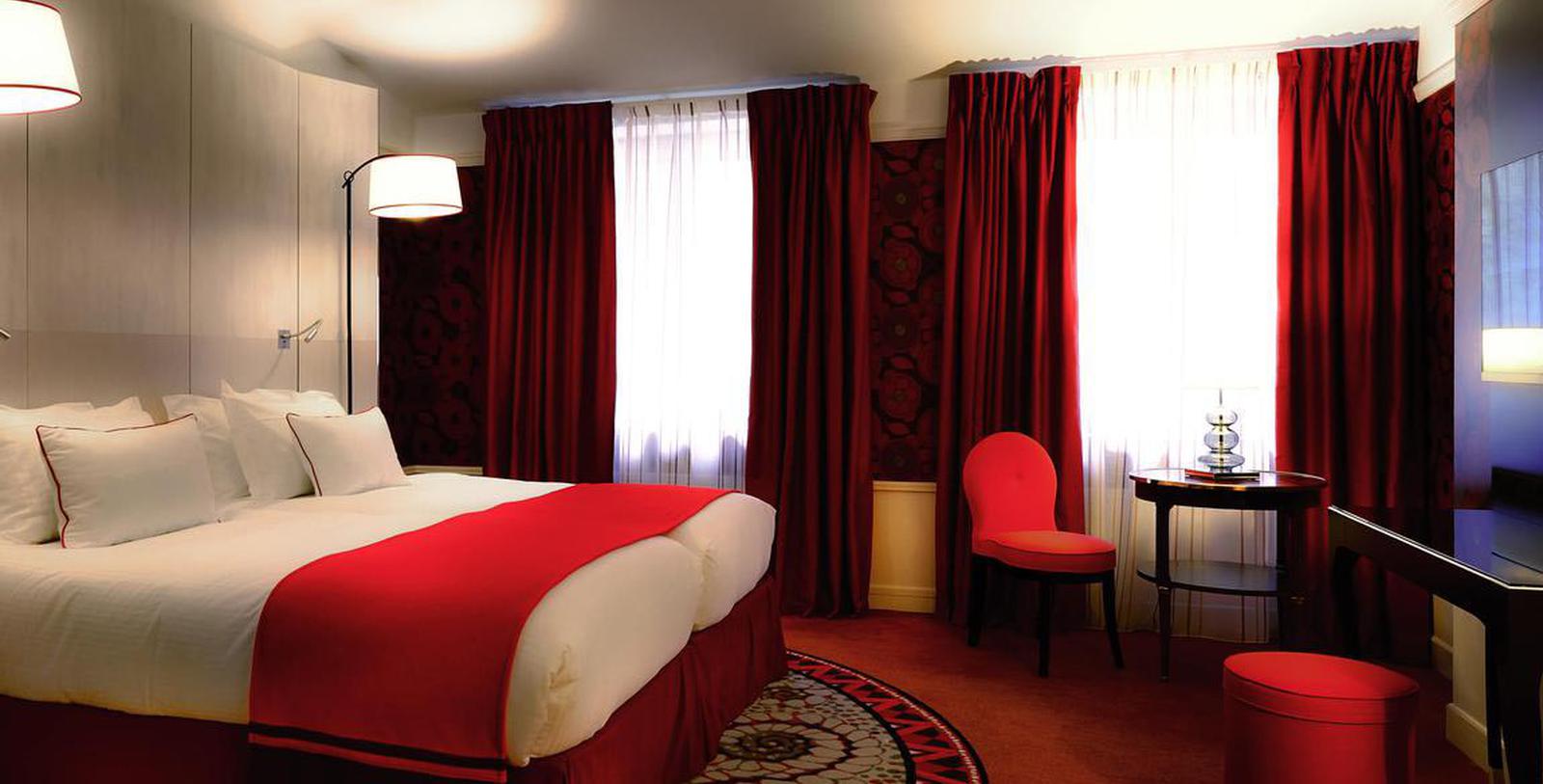 a bedroom with red curtains and a bed