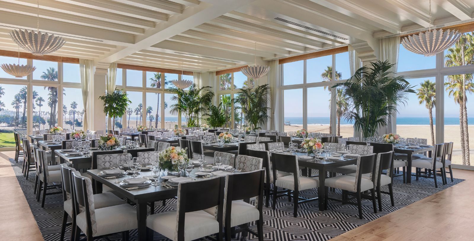 a room with tables and chairs and palm trees