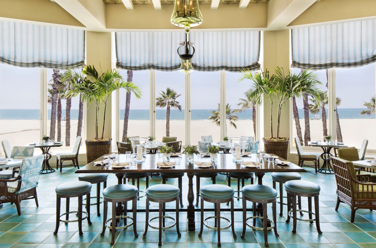 a room with a table and chairs and palm trees