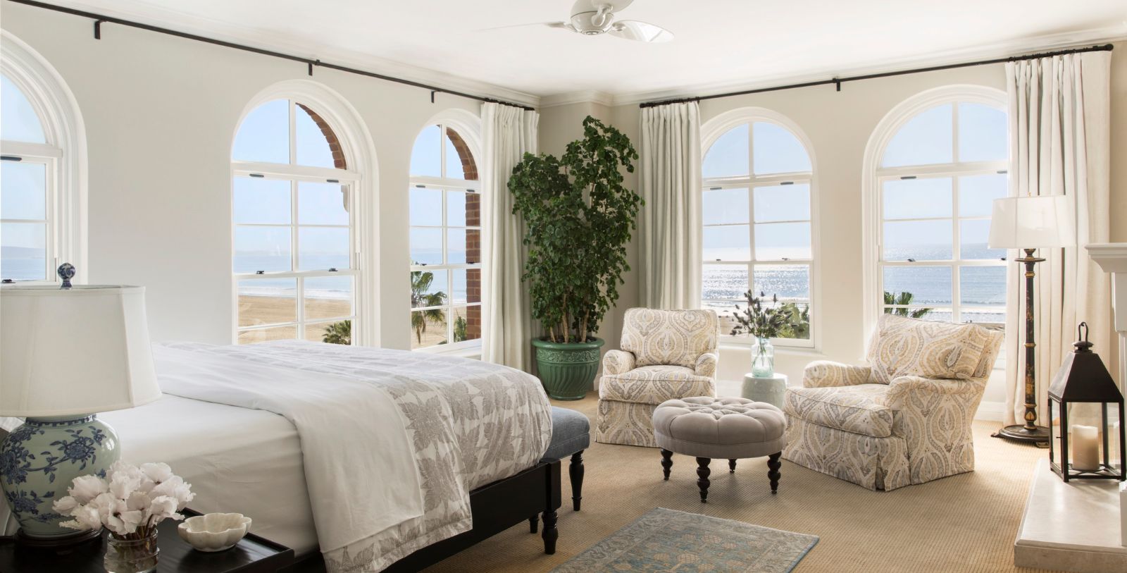 a bedroom with a large bed and chairs