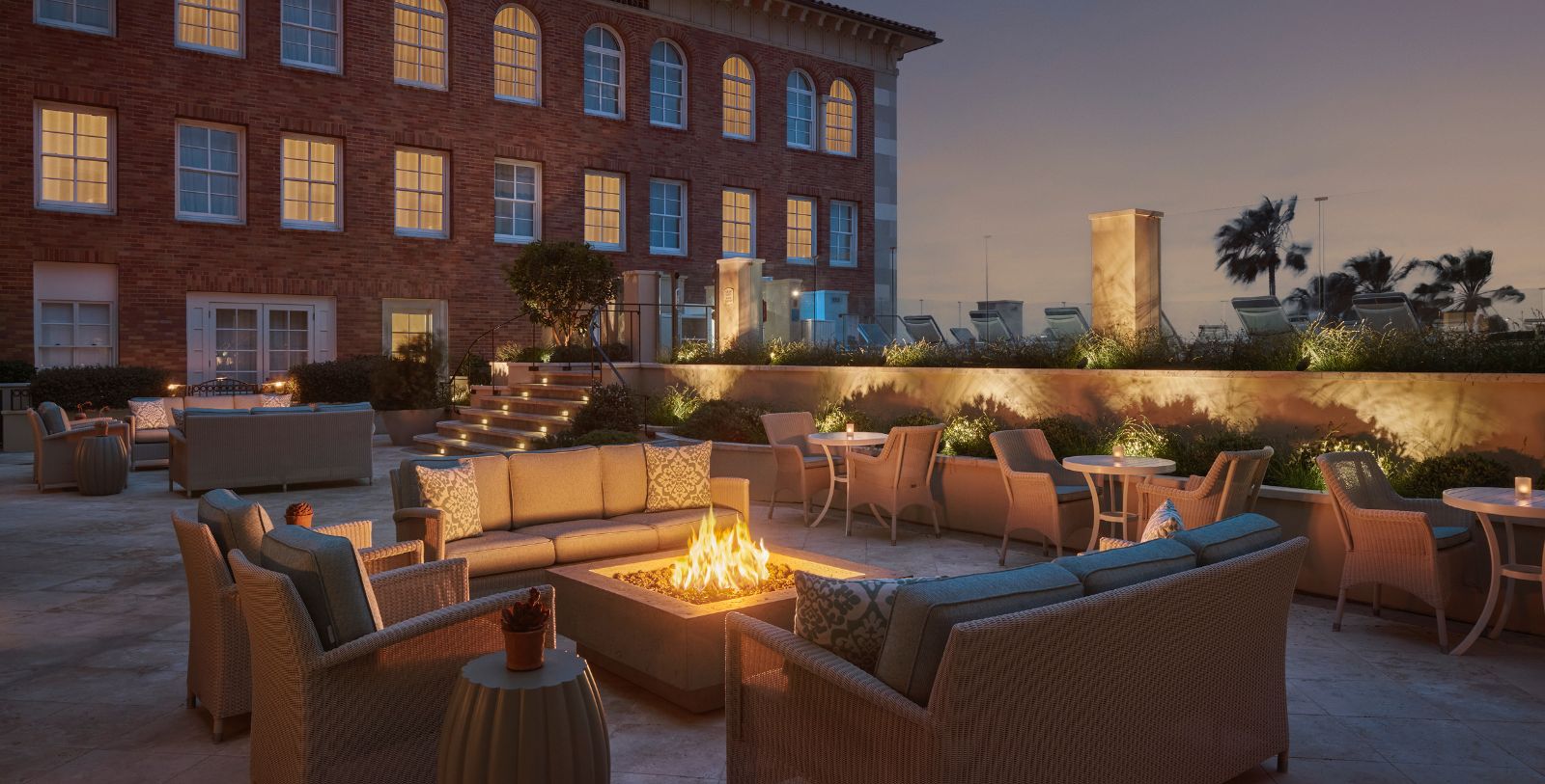 a fire pit with chairs and tables outside of a building