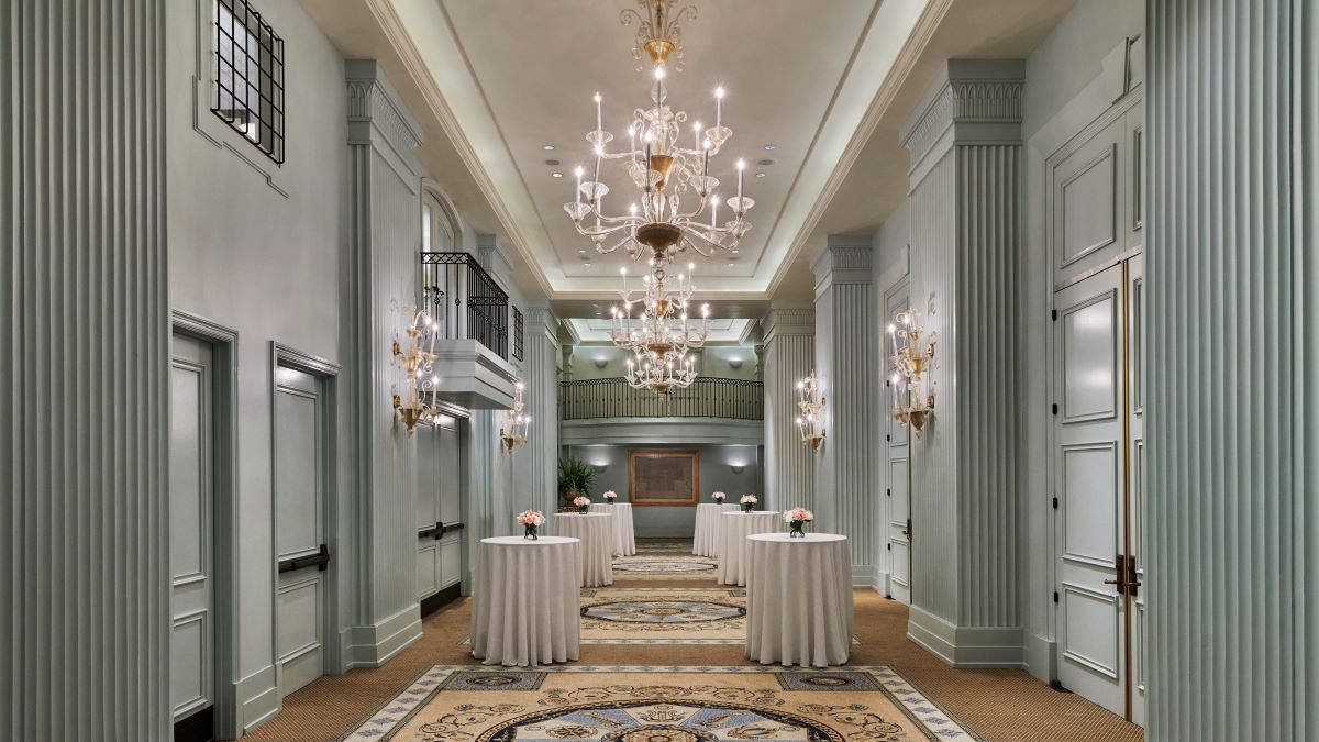 a long hall with tables and chandeliers