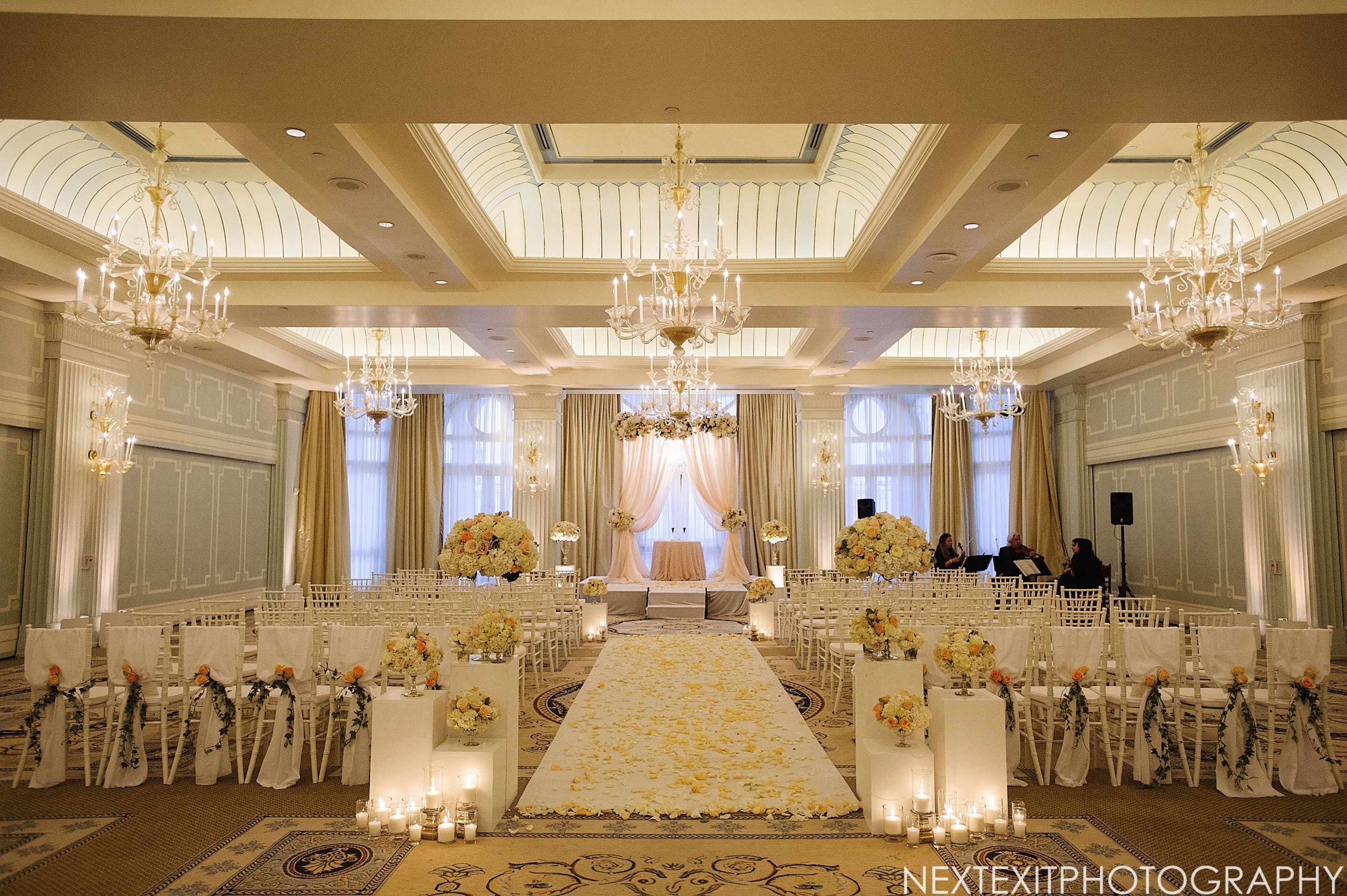 a wedding ceremony with chandeliers and chairs