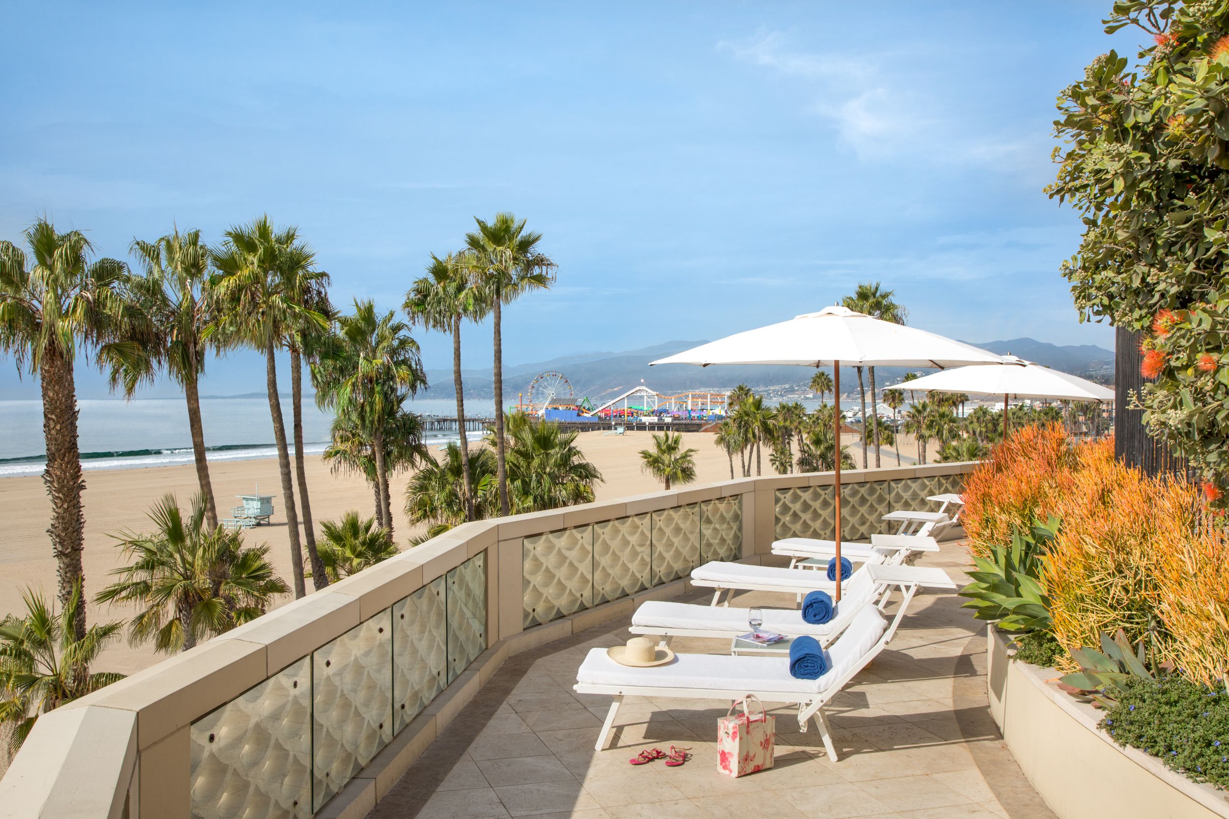a deck with chairs and umbrellas on a beach