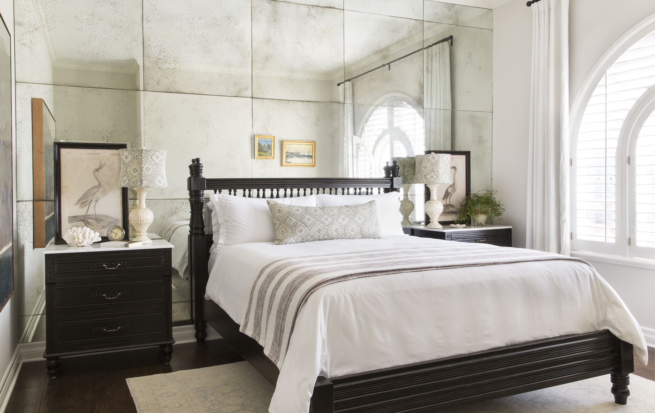 a bed with a mirror above it