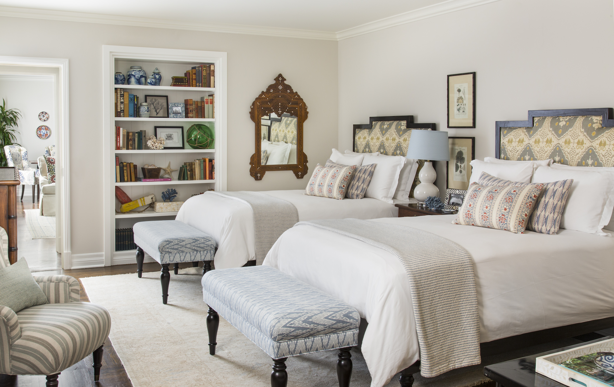 a room with two beds and a bookcase
