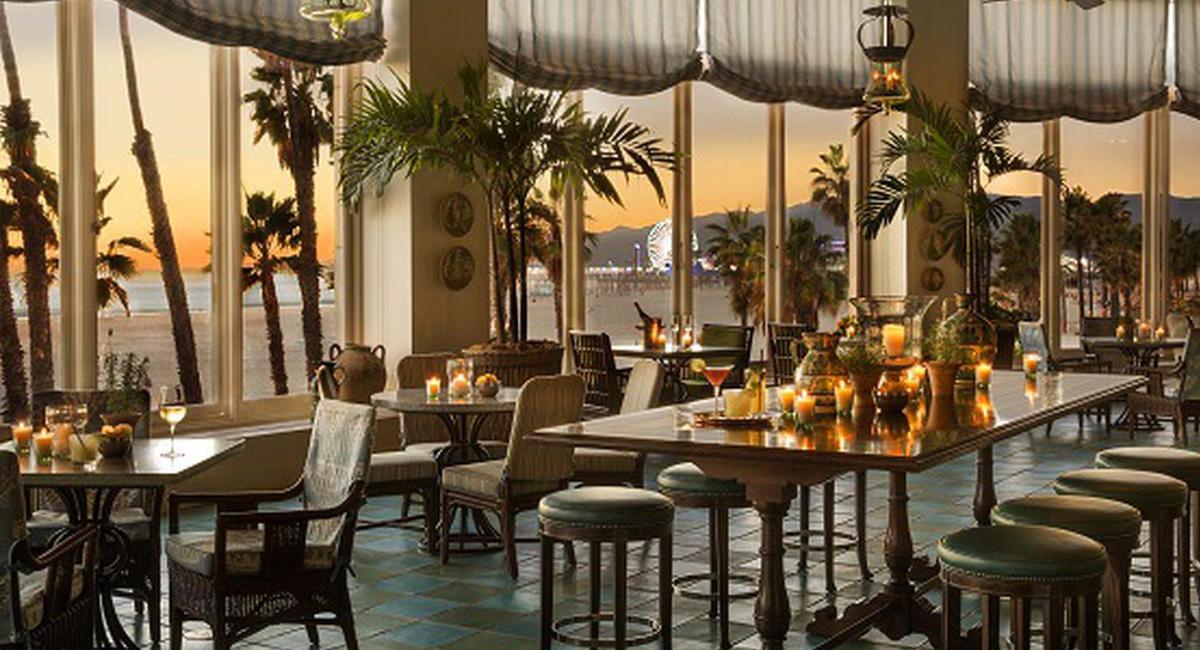 a room with tables and chairs and palm trees
