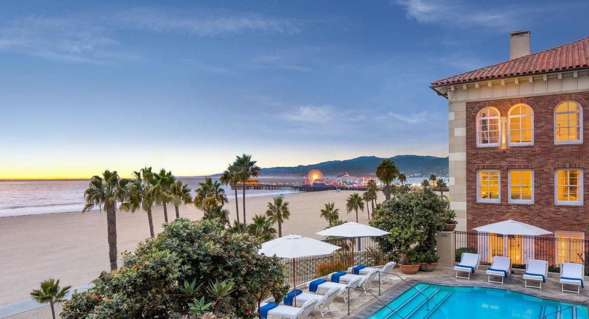a pool and beach with a pier in the background