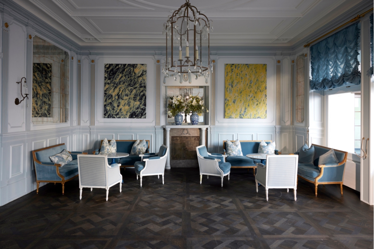 a room with white furniture and blue couches