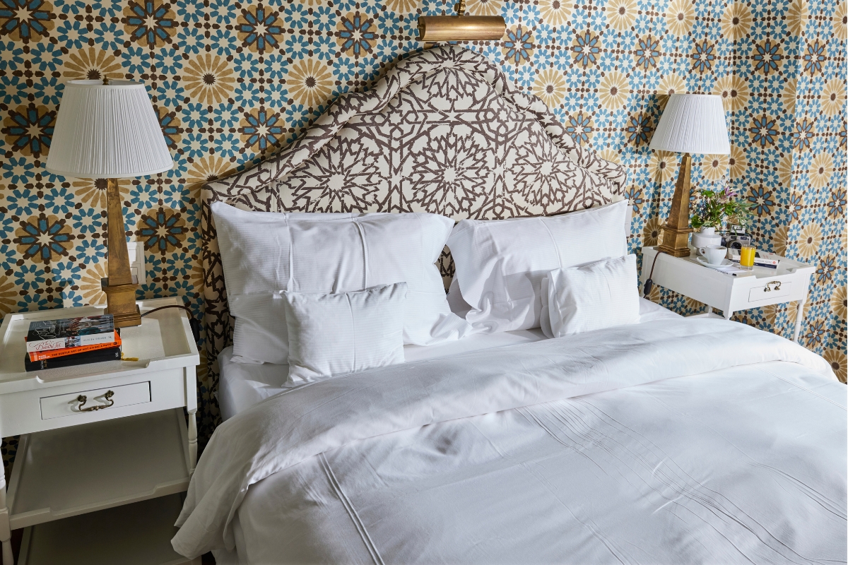 a bed with white sheets and pillows
