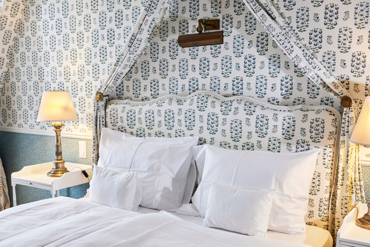 a bed with white pillows and a canopy over it