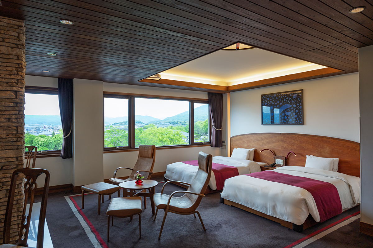 a room with two beds and chairs