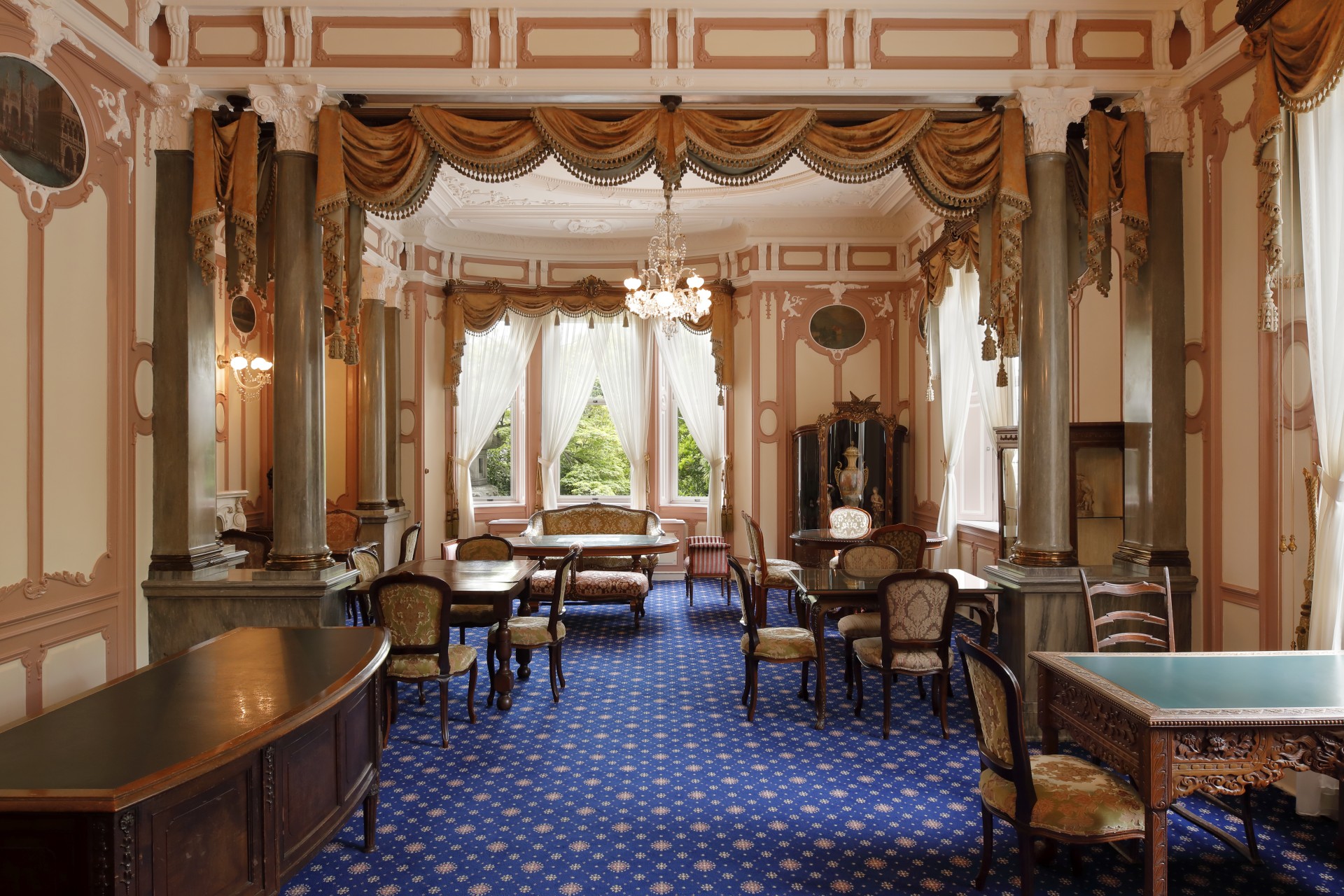 a room with blue carpet and tables and chairs