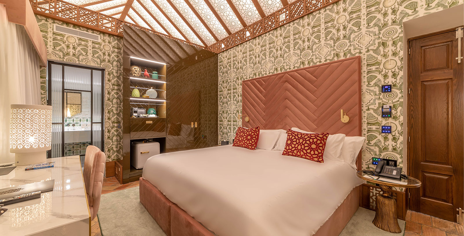a bed with red pillows in a room with a glass wall