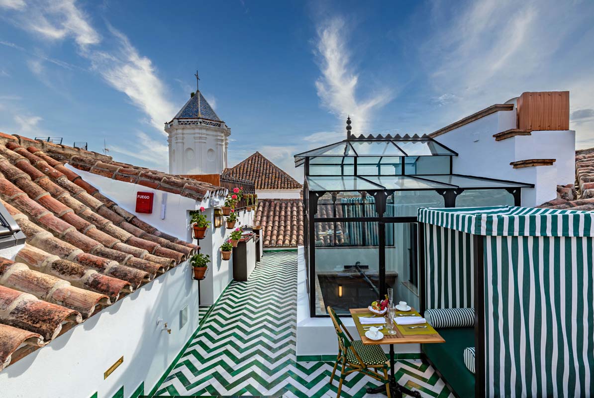 a rooftop patio with a glass roof and a green and white striped roof