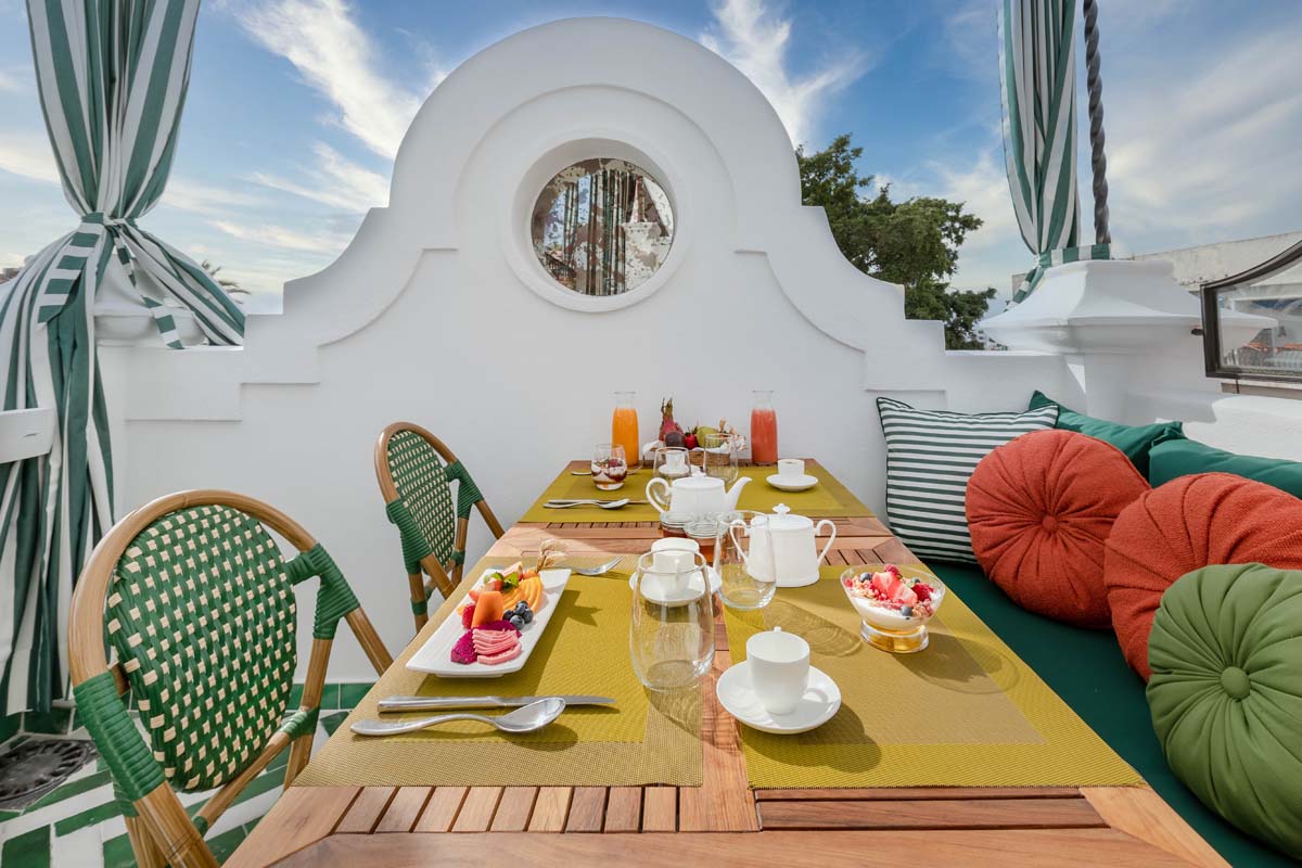 a table set for breakfast on a balcony