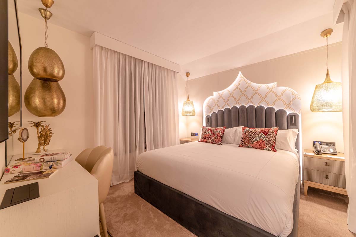 a bed with pillows and a lamp in a room