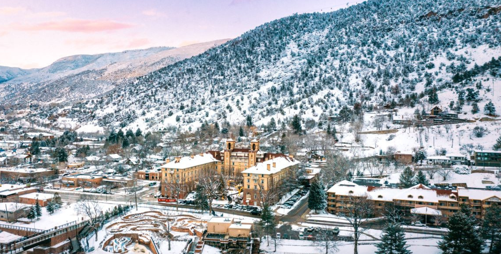 a snowy mountain with buildings and trees