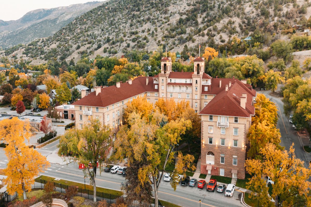 a building with trees and mountains in the background