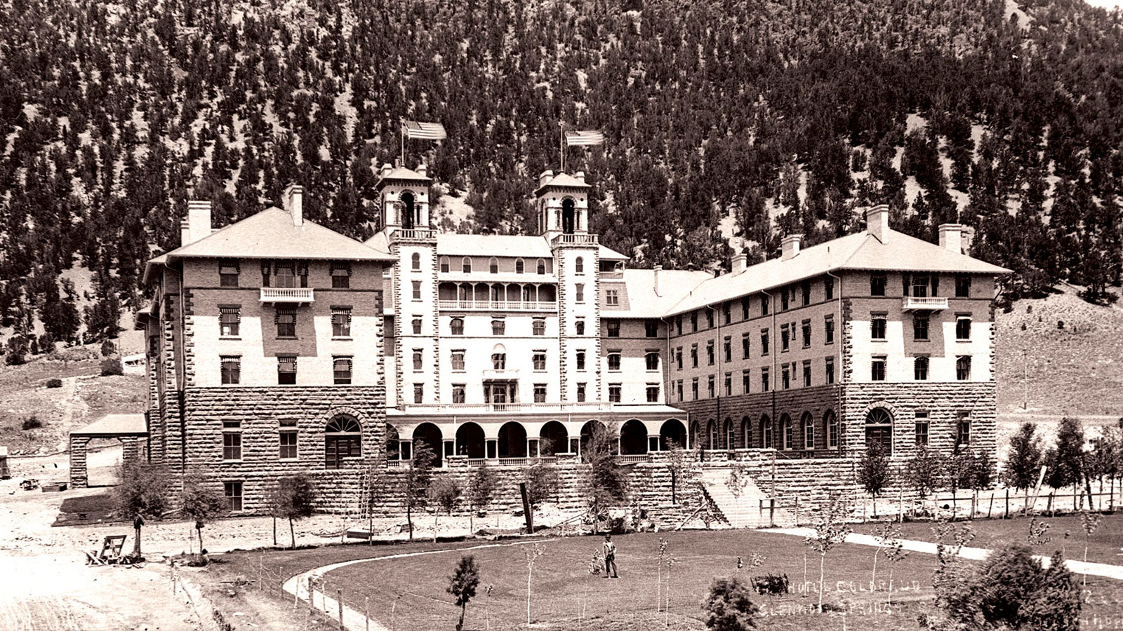 a large building with a lawn and trees