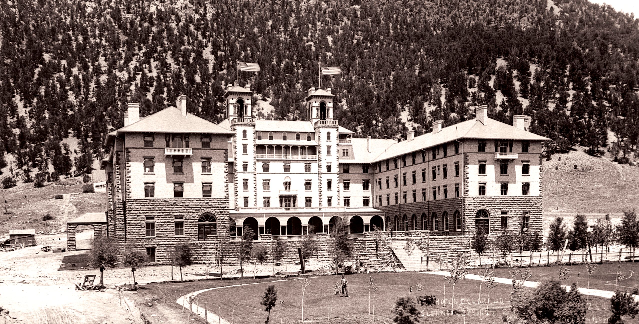a large building with a lawn and trees