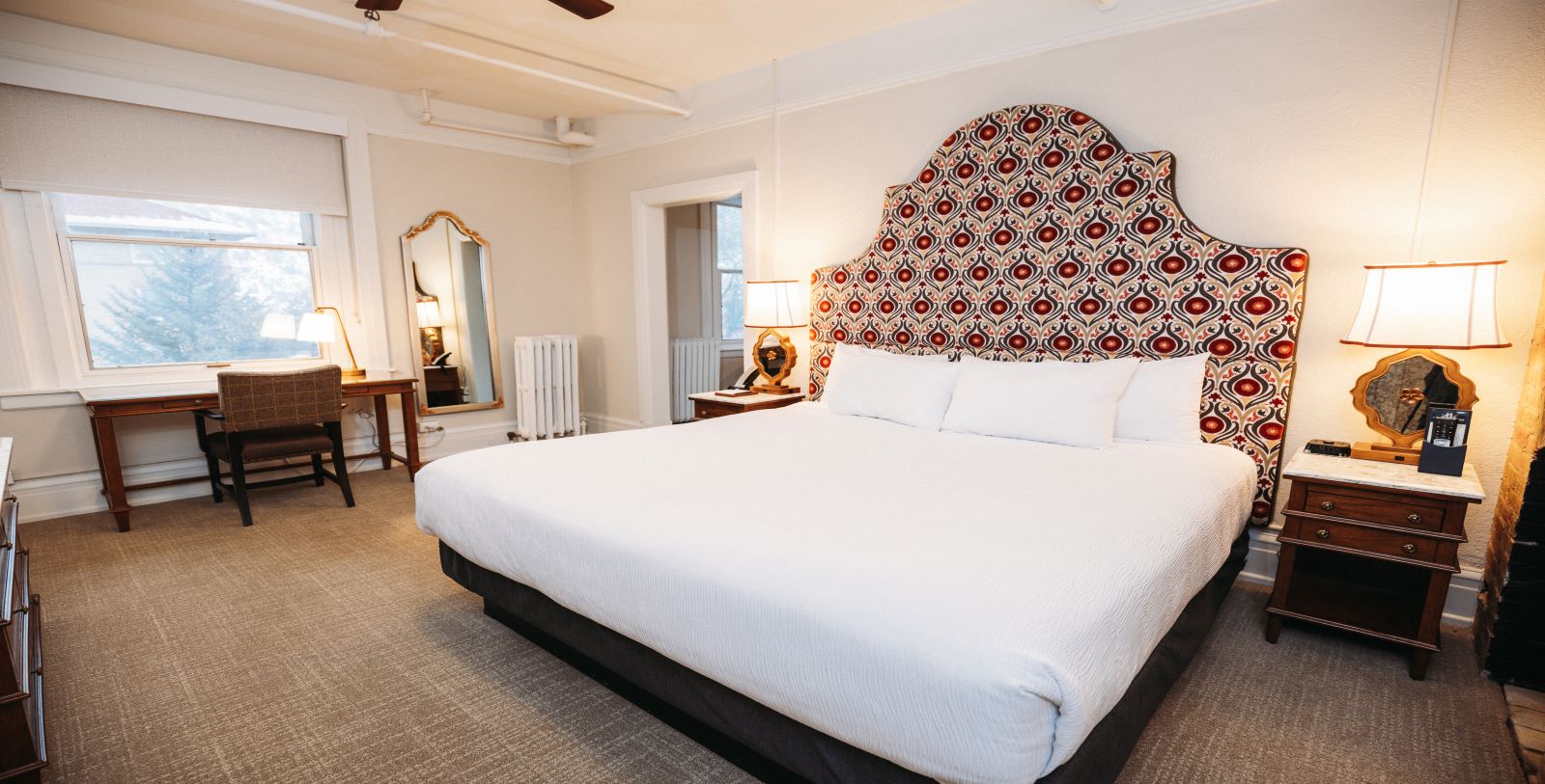 a bed with a patterned headboard in a room
