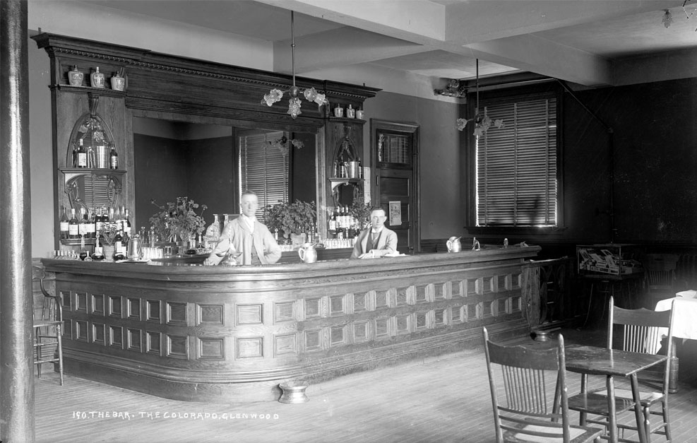 a man standing behind a bar