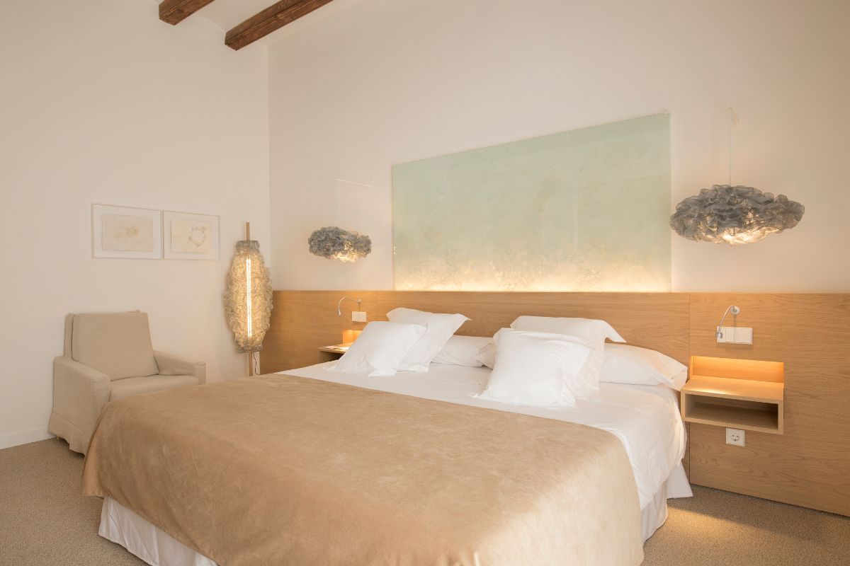 a bed with pillows and a chair in a room