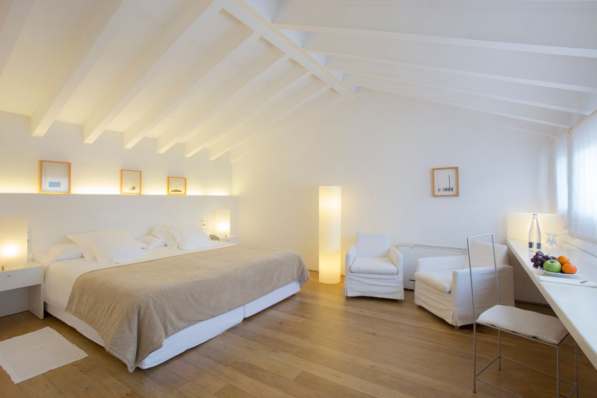 a bedroom with a bed and chairs
