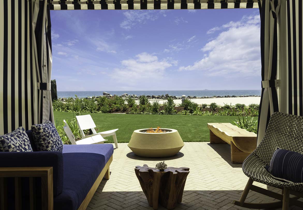 a patio with a fire pit and chairs