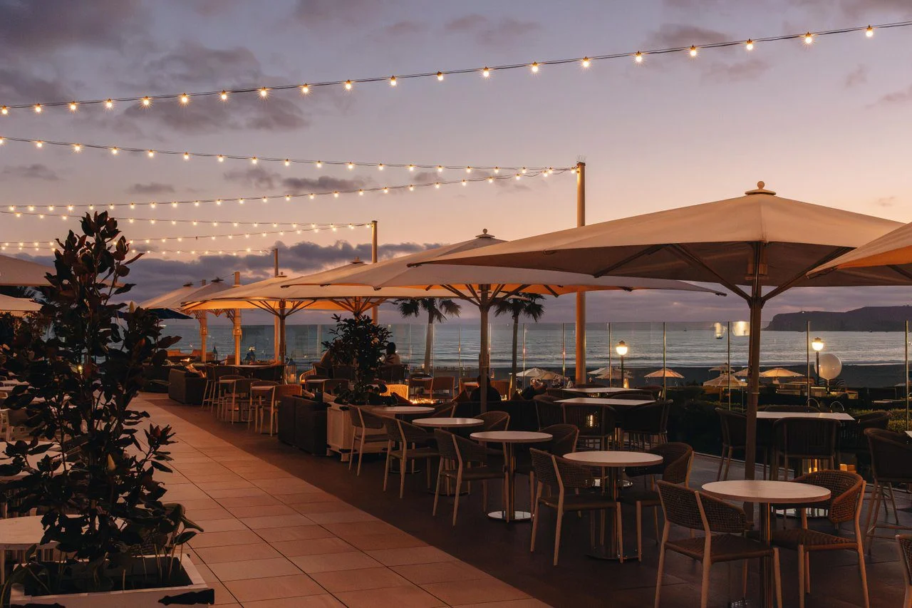 a patio with tables and umbrellas and lights
