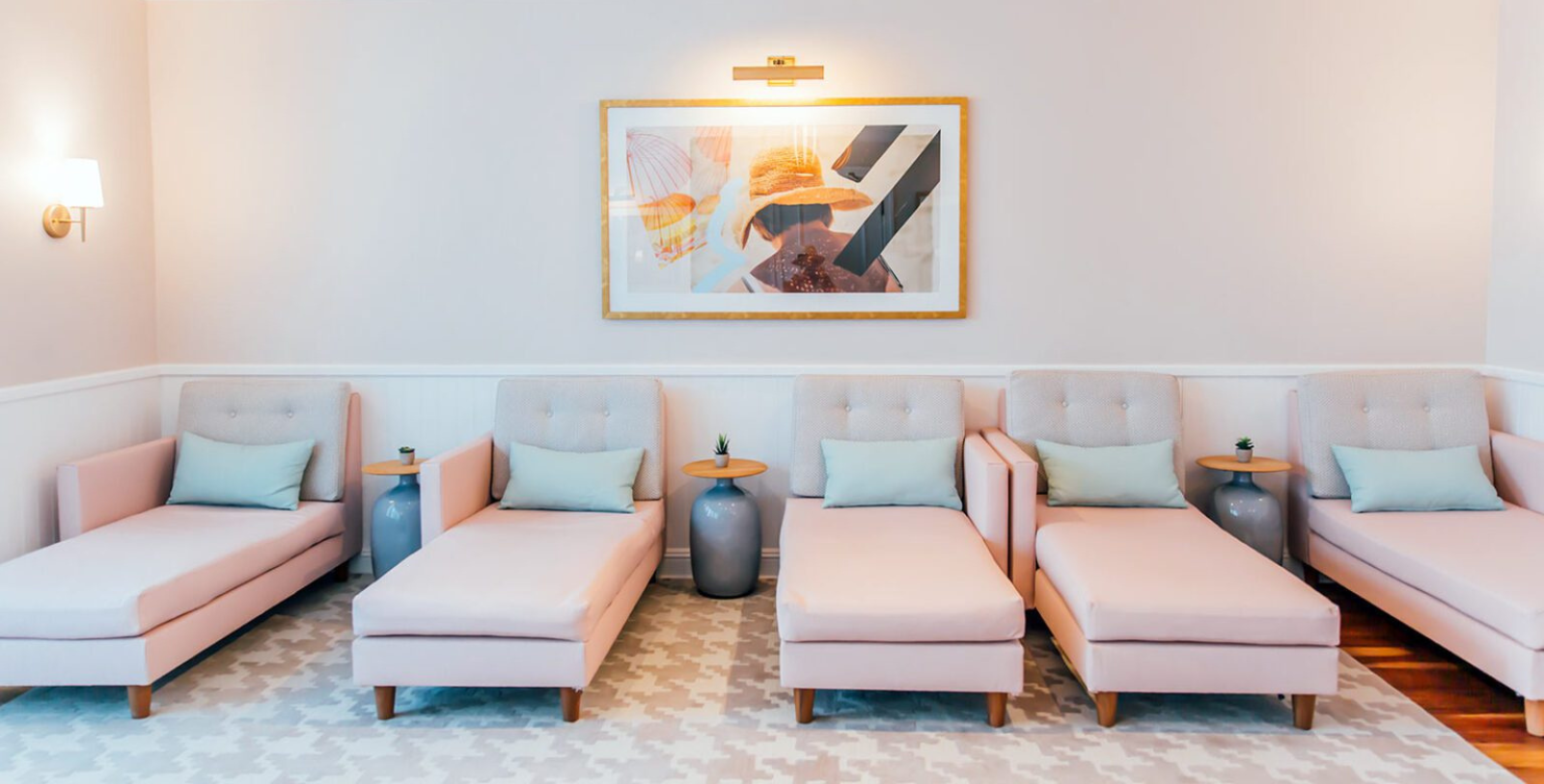 a group of pink chairs and a painting on the wall