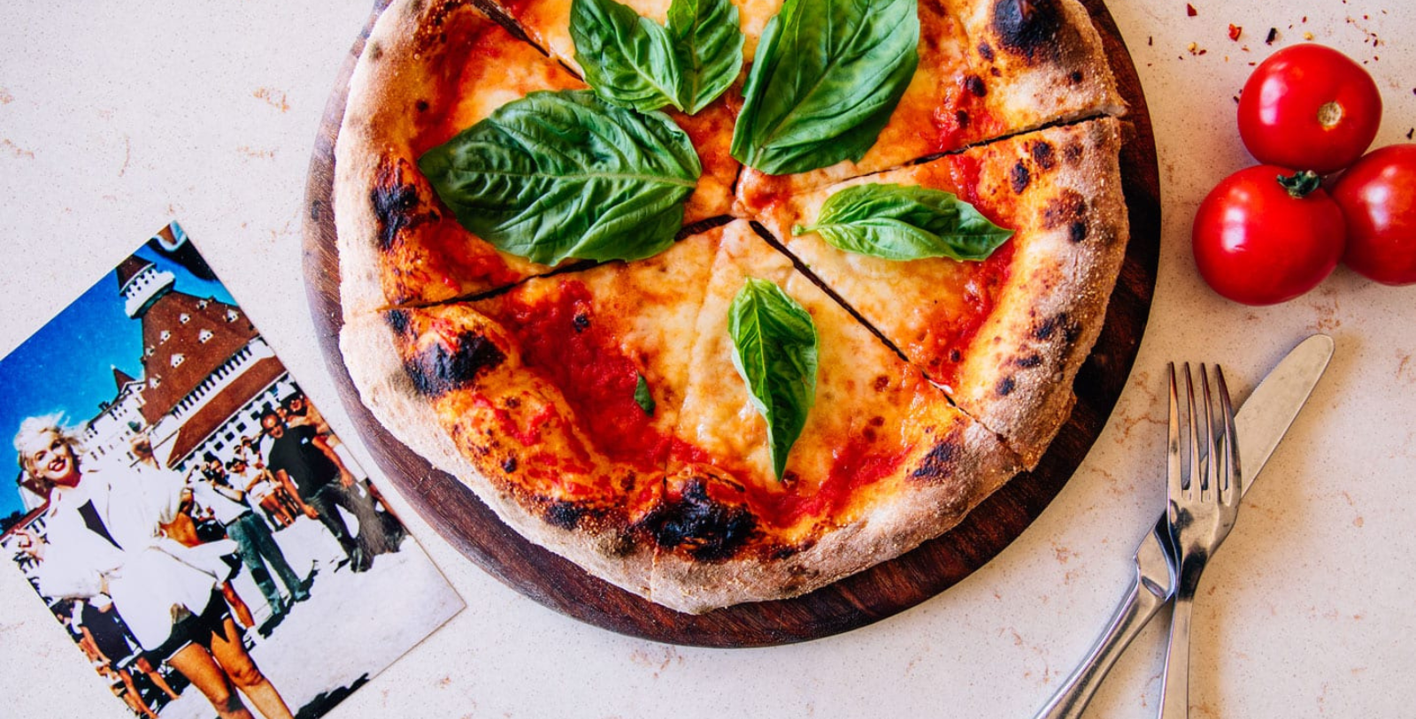 a pizza with basil leaves on top