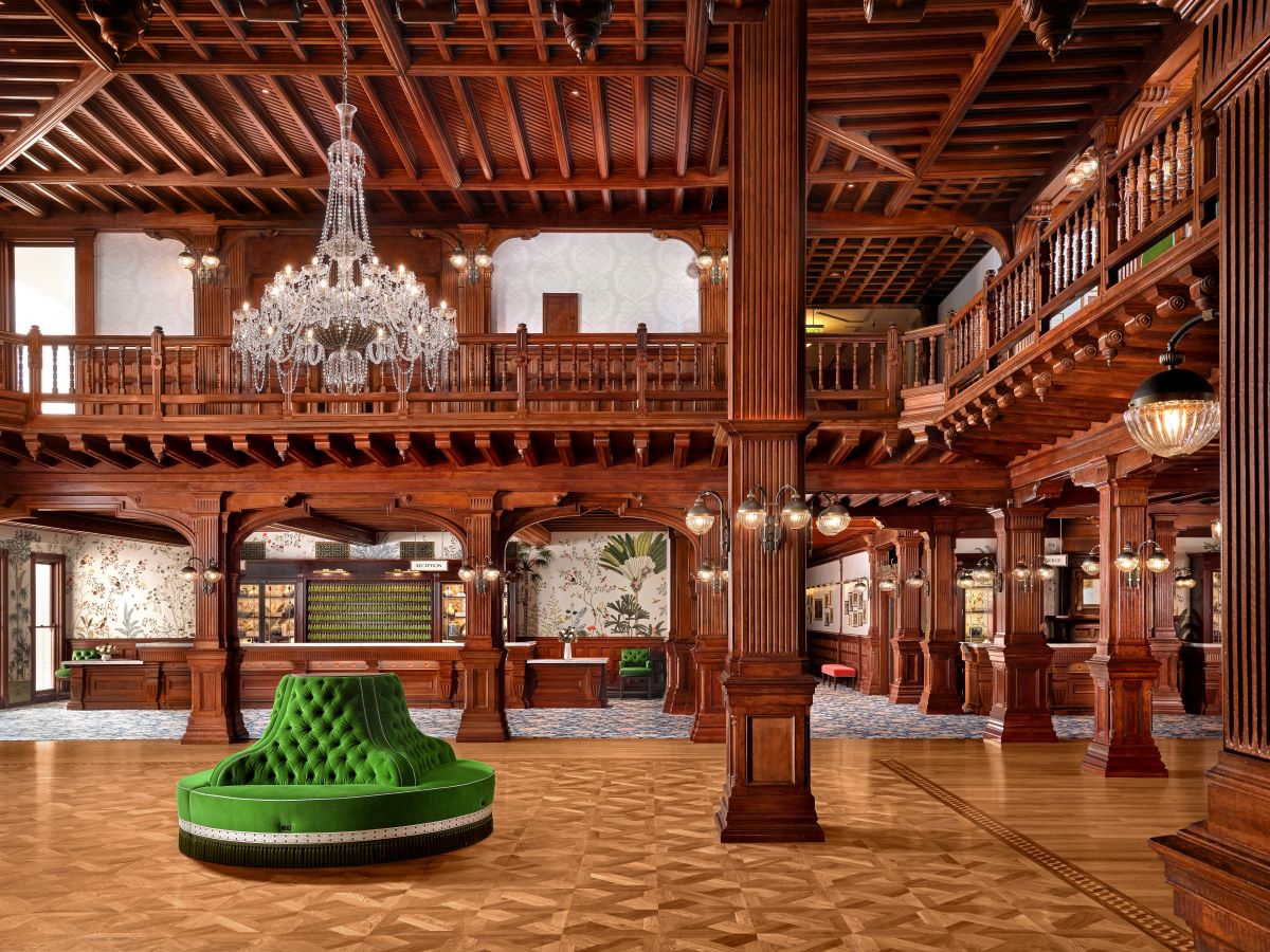 a large room with a green couch and chandelier