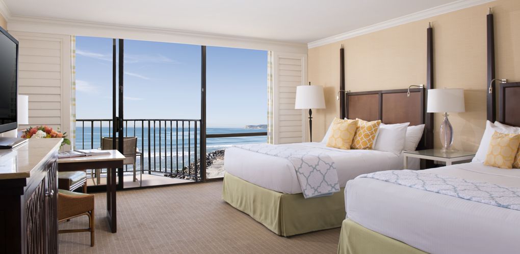 a hotel room with a balcony overlooking the ocean