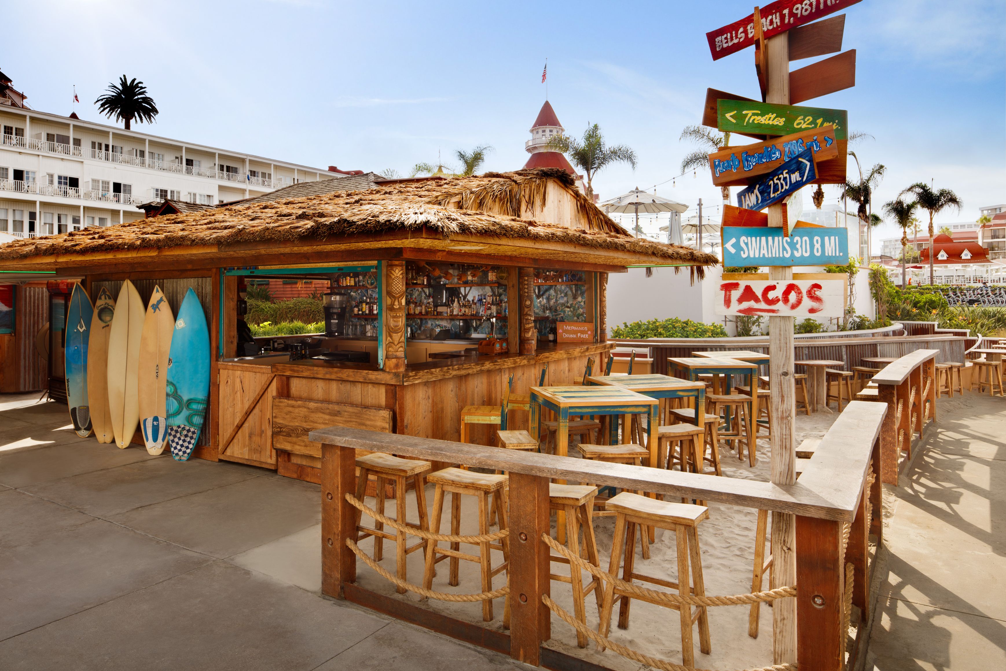 a small hut with a signpost and surfboards